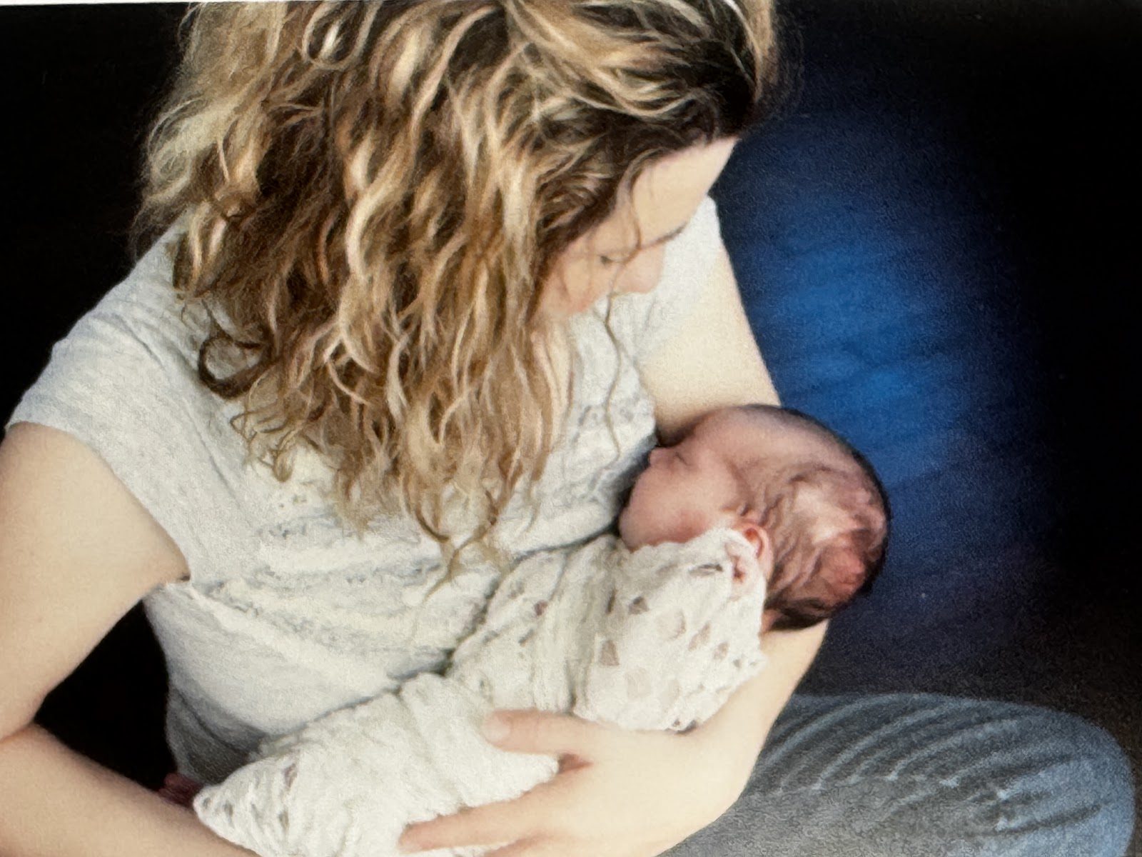 Laura gently holding a newborn baby