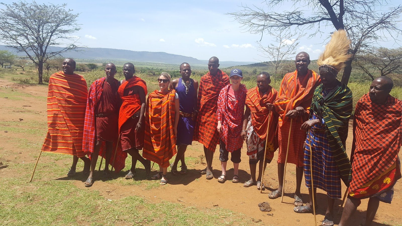 A group of Maasai people in red robes standing together on the plains