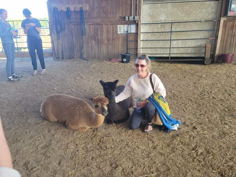 Laura kneeling with animals at a sanctuary