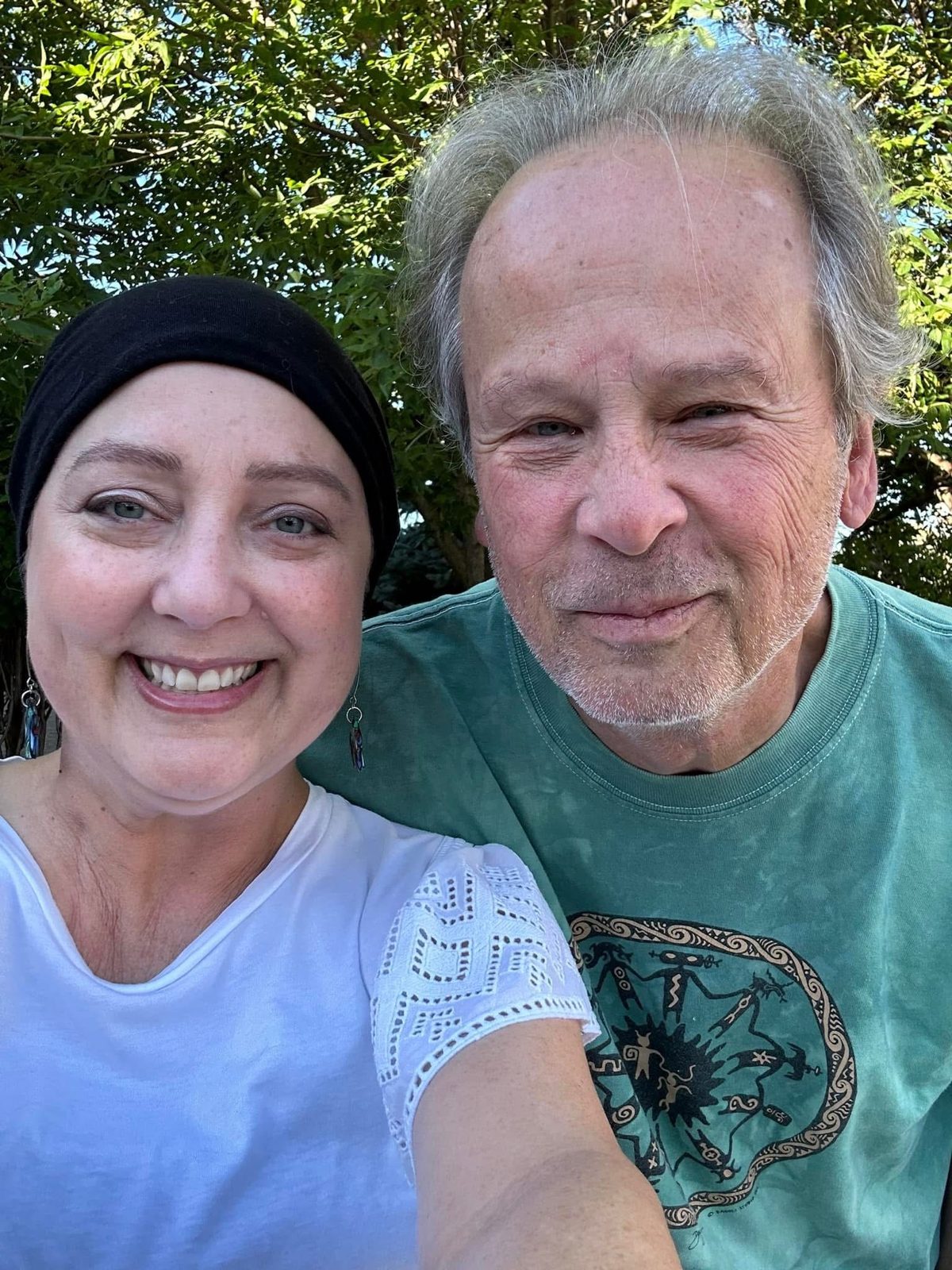 Laura smiling in a selfie with an older friend outdoors