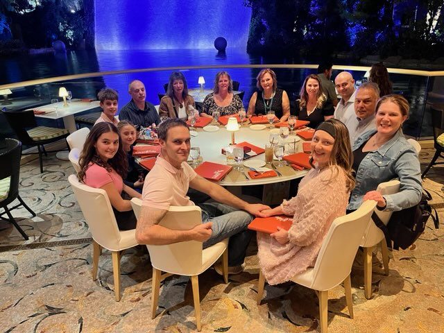 Family and friends around a round dinner table at Laura's 50th birthday